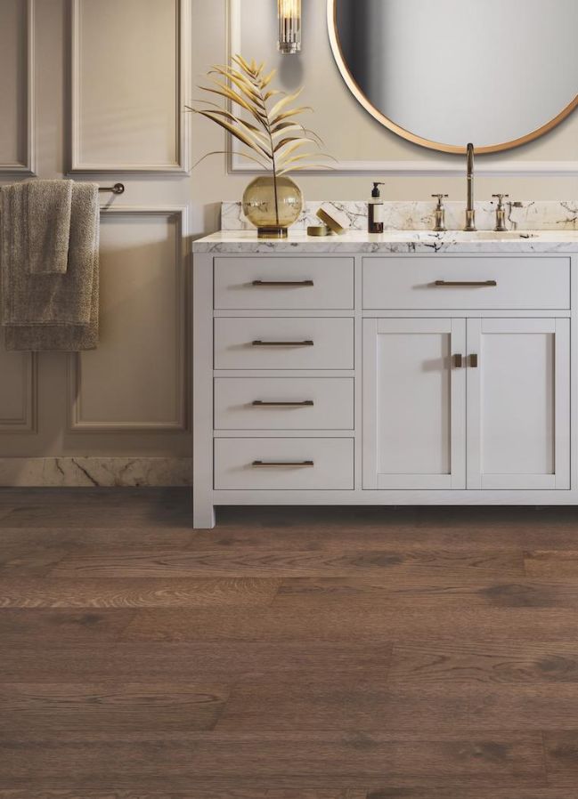 hardwood flooring in a FL bathroom with gray vanity and mirror